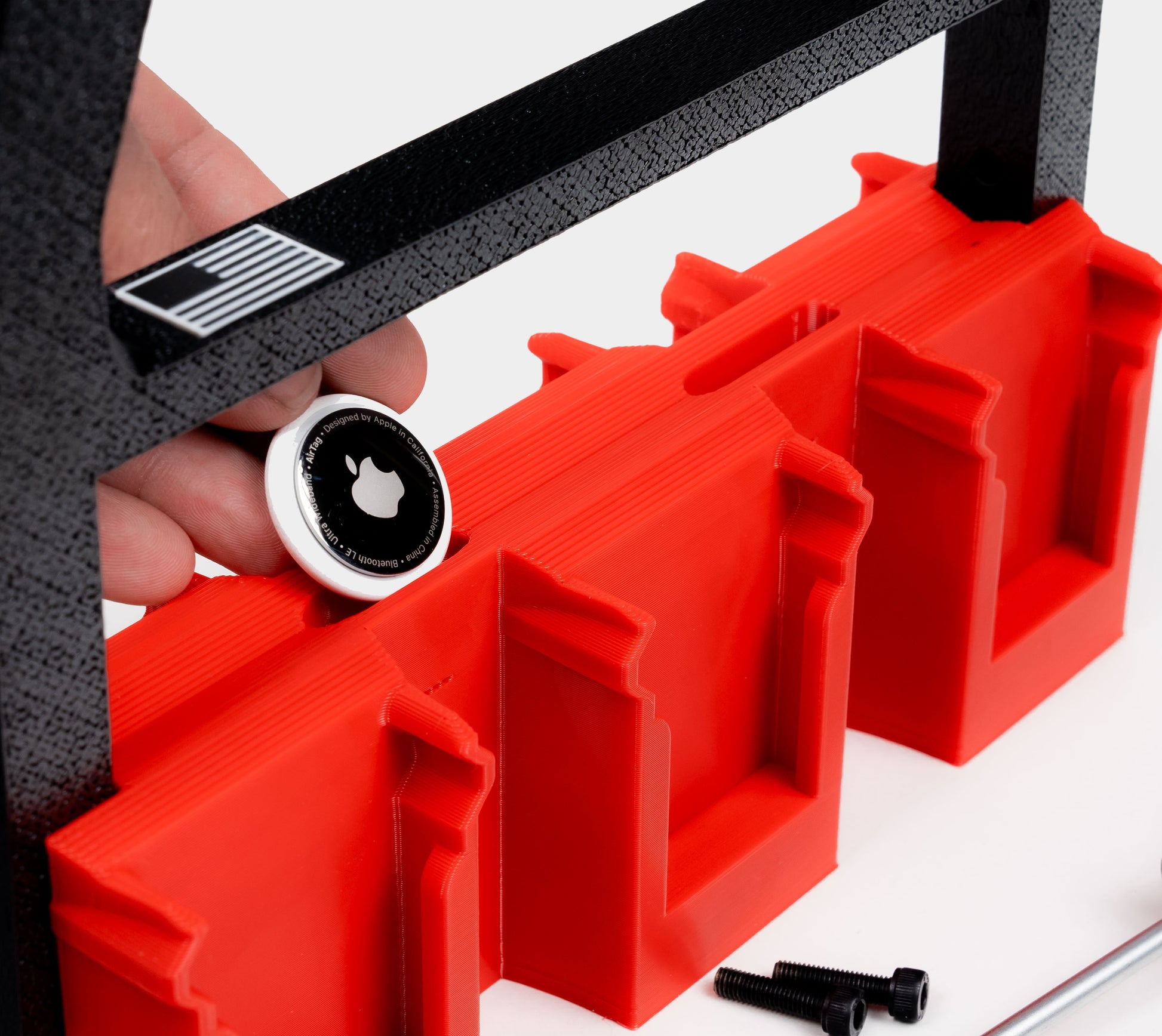 AirTag being inserted into hidden tracker pocket of Milwaukee battery pack